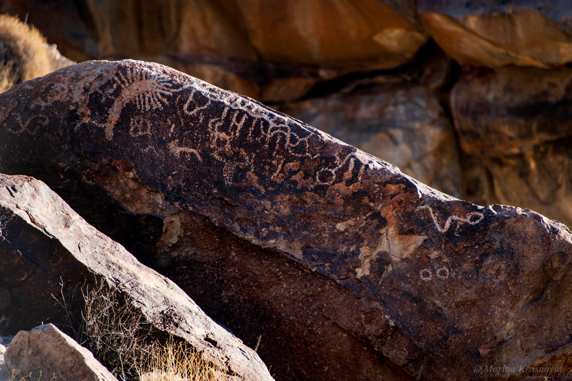 Linear petroglyph patterns carved into dark volcanic rock at Grapevine Canyon, Nevada