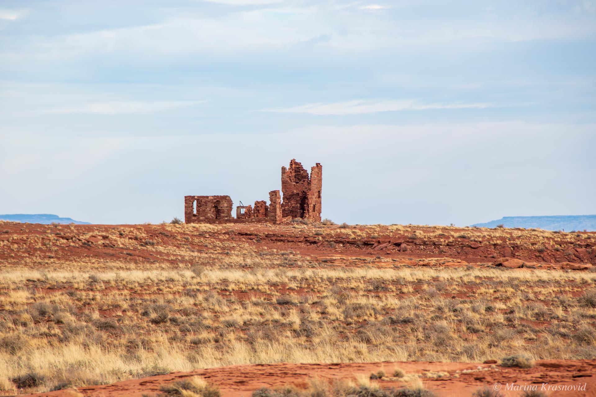 Distant view of stone ruins near Meteor Crater in northern Arizona, remnants of early twentieth-century structures built during mining and research efforts.